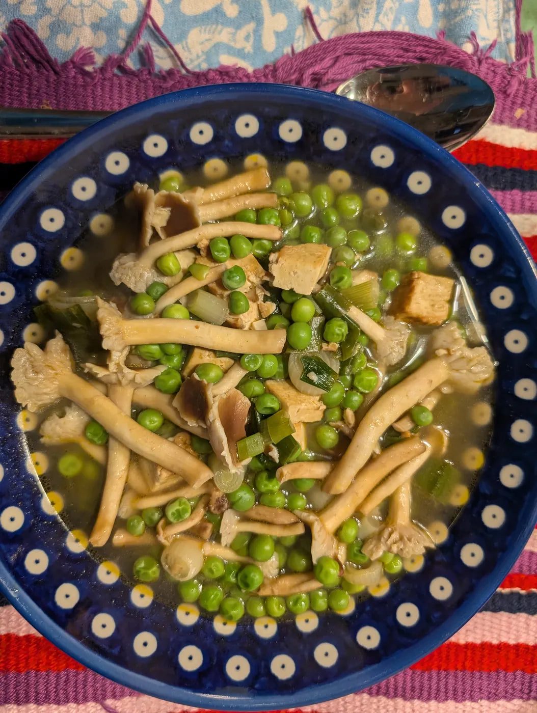 Teller mit Nudeln, grünen Erbsen und Pioppino-Pilzen